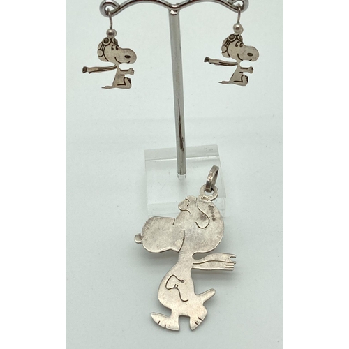 201 - A large silver pendant of Snoopy in a flying hat and scarf, with matching drop earrings. Hallmarks t... 