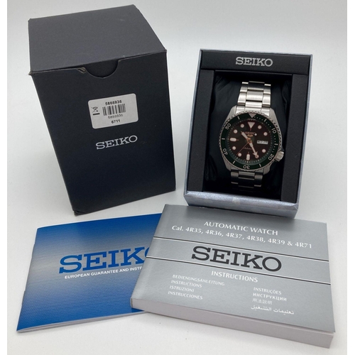 317 - A Seiko 5 sports automatic wristwatch with green face and bezel. Stainless steel strap and skeleton ... 