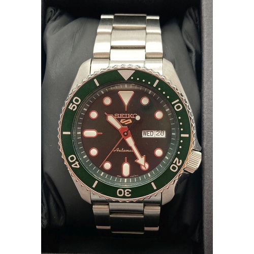 317 - A Seiko 5 sports automatic wristwatch with green face and bezel. Stainless steel strap and skeleton ... 