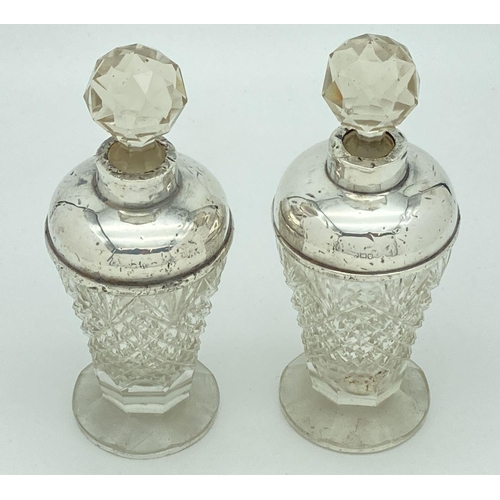 338 - A pair of early 20th century cut glass scent bottles with silver collars and shoulders. Hallmarks pr... 