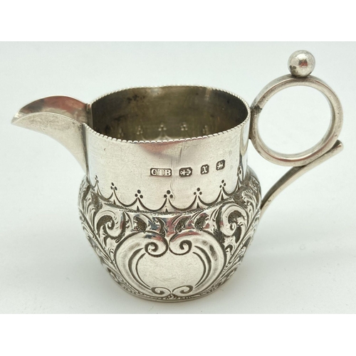 339 - A small Victorian silver cream jug decorated with scrolls and waves of foliage. Loop design handle s... 