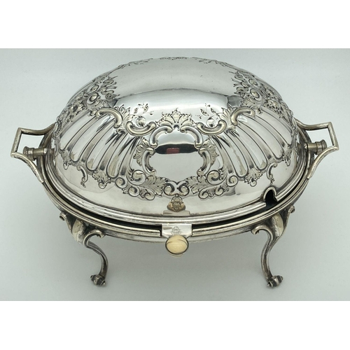 346 - An antique silver plated, oval shaped, revolving dome toped warming dish. With decorative floral and... 