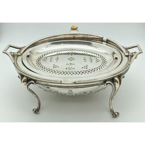 346 - An antique silver plated, oval shaped, revolving dome toped warming dish. With decorative floral and... 