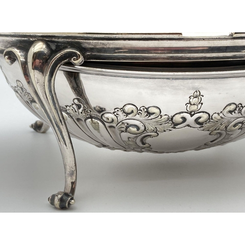 346 - An antique silver plated, oval shaped, revolving dome toped warming dish. With decorative floral and... 