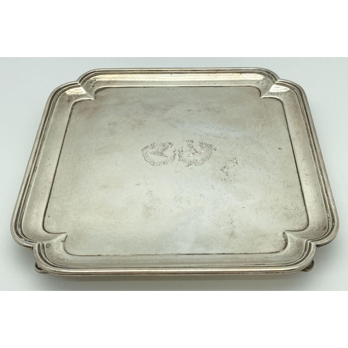 369 - An Art Deco square shaped silver salver raised on 4 feet with stepped design to rim. Engraved to cen... 