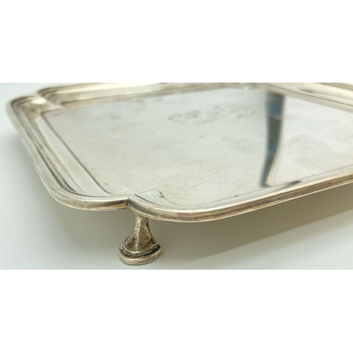 369 - An Art Deco square shaped silver salver raised on 4 feet with stepped design to rim. Engraved to cen... 