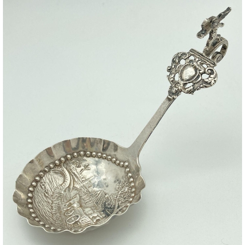 371 - An antique Dutch silver tea caddy spoon with hooked handle. Bowl has scalloped rim and a decorative ... 