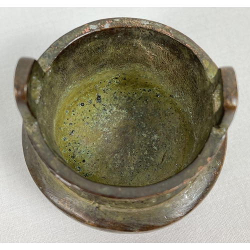 1208 - A miniature Chinese bronze censer with loop handles and raised on tapered tripod legs. Impressed mar... 