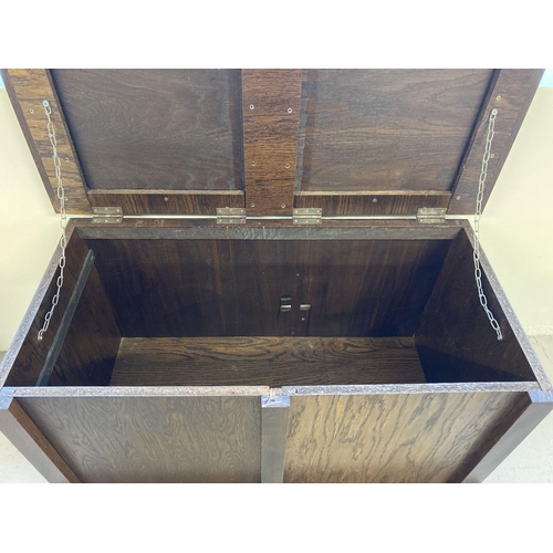 1369 - A heavy oak veneer panelled storage chest/box with front shaped feet and interior lid support chains... 