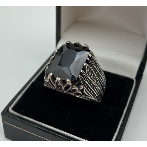 1015 - A silver statement cocktail ring set with a large octagon cut black spinel stone. Decorative pierced... 
