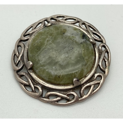 1030 - A vintage Celtic pierced work brooch set with a round green agate stone. Silver marks to reverse. Ye... 
