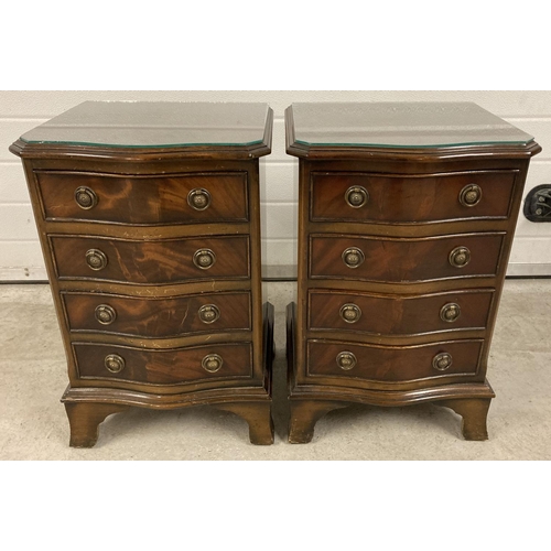 1384 - A pair of reproduction dark wood bow fronted chests. Each with 4 drawers, drop down brass handles an... 