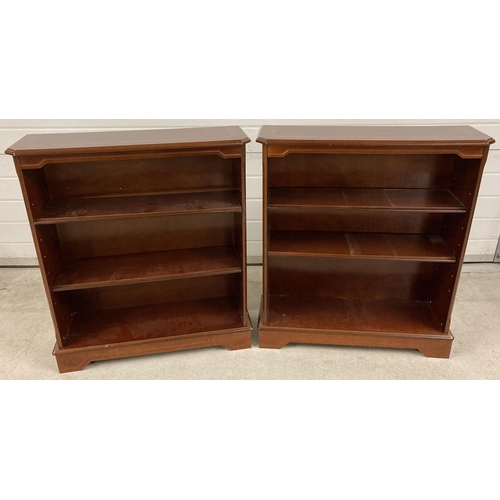 1386 - A pair of modern mahogany coloured book shelves with inlaid detail to tops. Each with 2 adjustable s... 