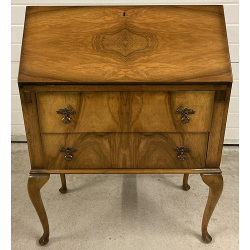 1387 - A vintage walnut veneer 2 drawer bureau, raised on cabriole legs. With interior stationary compartme... 