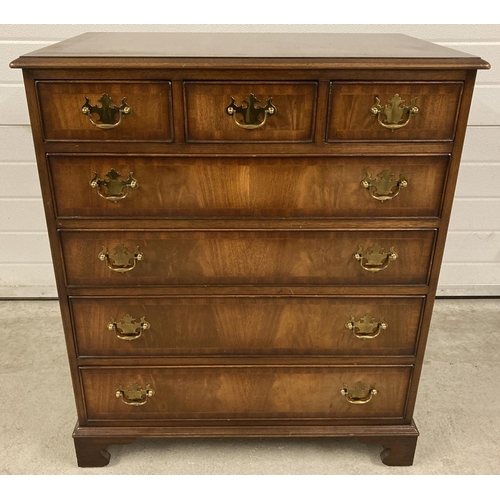 1391 - A modern reproduction solid dark wood 7 drawer chest with brass drop down handles. 3 small drawers o... 