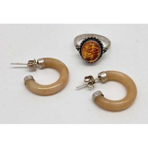 69 - 2 items of white metal and amber jewellery. A modern design ring set with an oval cabochon of cognac... 