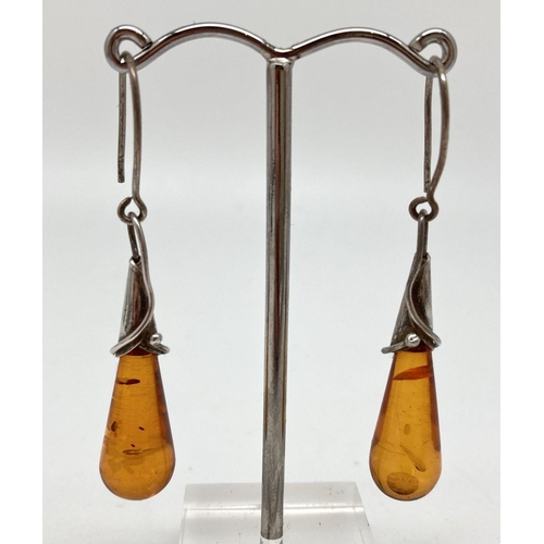 71 - A pair of white metal and cognac amber Art Nouveau design drop earrings. With hooked wires, drop app... 