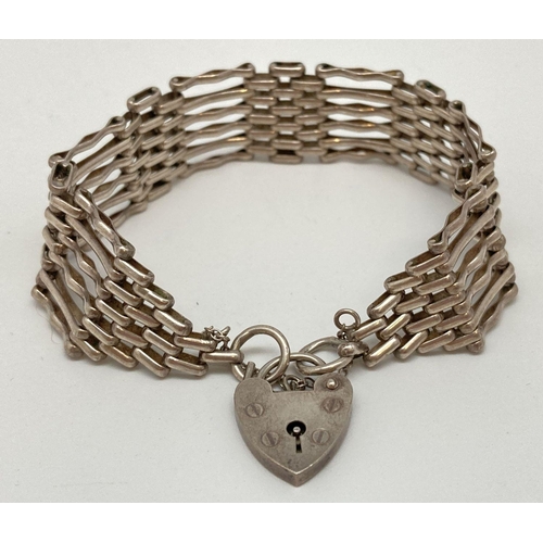 79 - A vintage silver 6 bar gate bracelet with padlock shaped clasp and safety chain. Approx. 7.5 inches ... 