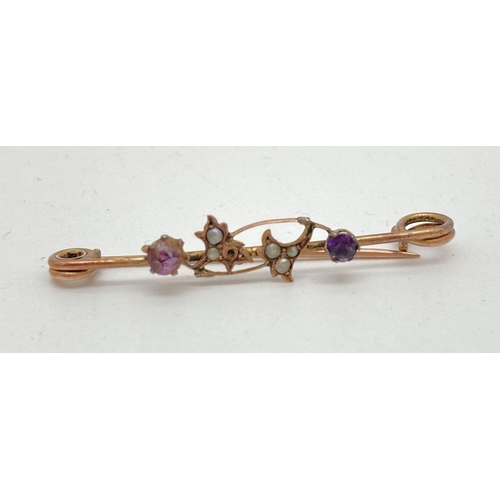 84 - A vintage 9ct gold bar brooch with floral detail set with amethysts and small seed pearls (one missi... 