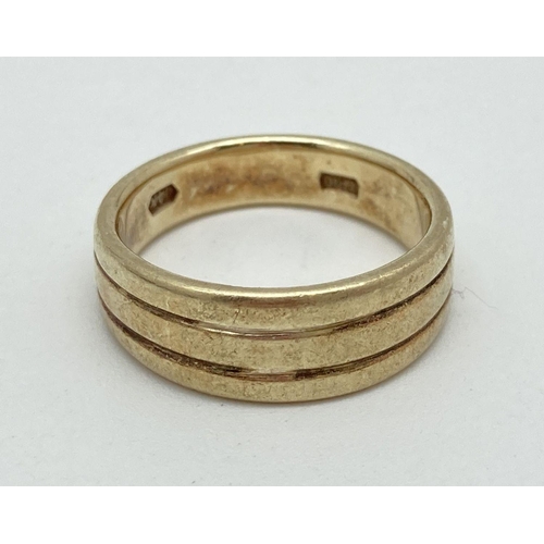 129 - A 14ct gold band style ring with chanelled detail. Inside of band marked 