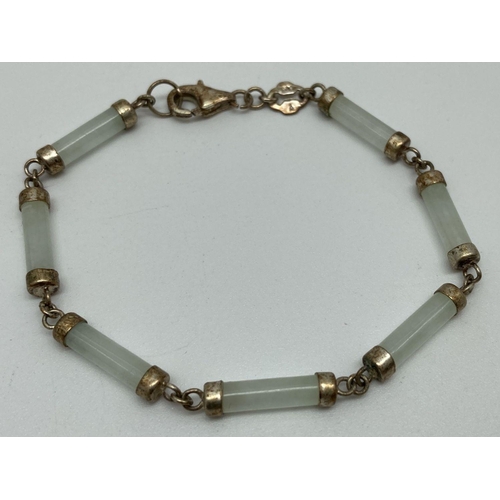 138 - A silver and pale green jade bracelet with lobster style clasp. Bracelet made from 7 small cylinder ... 