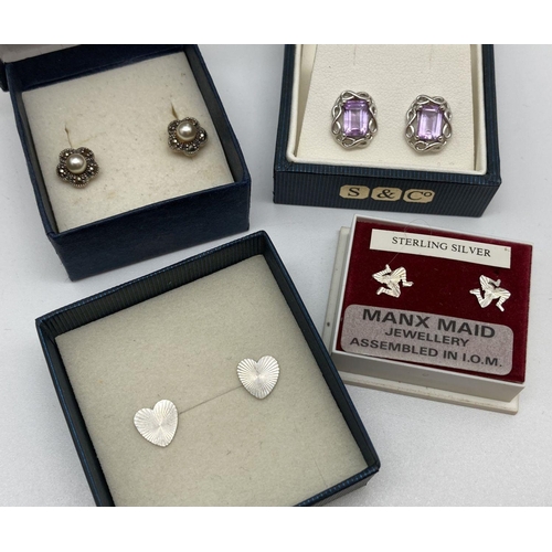 143 - 4 boxed pairs of silver earrings. A pair of heart studs with engine turned decoration, a pair of flo... 