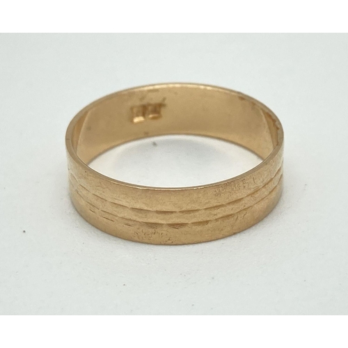 147 - A gold wedding band with diamond cut pattern. Indistinct marks to inside of band. Tests as 14ct gold... 