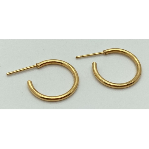 149 - A pair of gold hoop style earrings, test as 18ct gold. Approx. 1.5cm diameter. Total weight 1g.