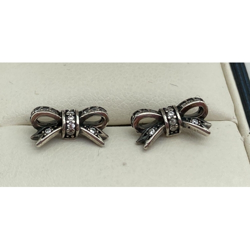 152 - A pair of clear stone set bow stud earrings by Pandora. Back of earrings marked S925 Ale.