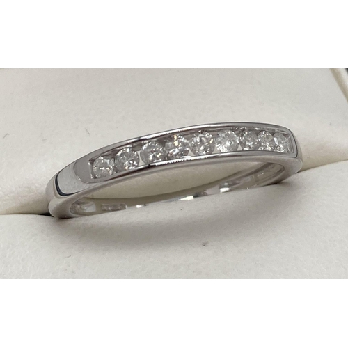 165 - A 9ct white gold ring with 0.25ct channel set round brilliant cut diamonds. Complete with diamond co... 