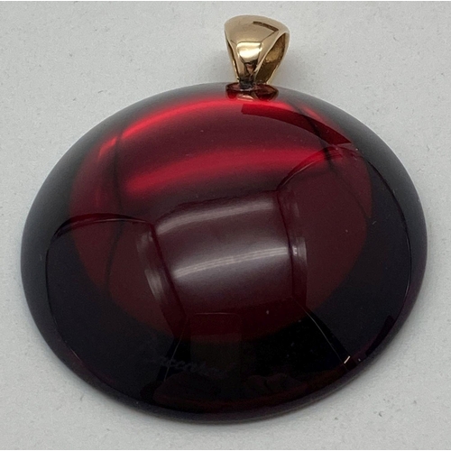 176 - A Baccarat crystal circular shaped dome topped pendantif with 18ct gold bale. In deep red with metal... 