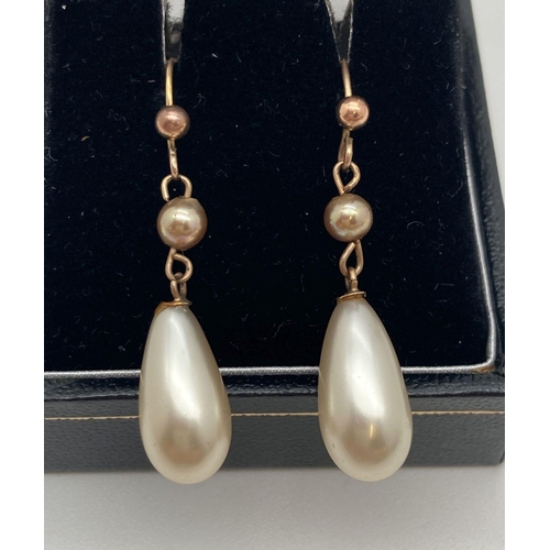 177 - A pair of 9ct gold and faux pearl drop earrings. Cream coloured drop pearls approx. 1.5cm long linke... 