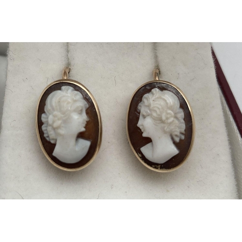 178 - A pair of oval shaped cameo earrings in gold mounts and with gold hook backs. Test as 9ct. Approx. 1... 