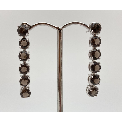 179 - A pair of 9ct white gold and smokey quartz earrings with articulated drops. Fully hallmarked to post... 