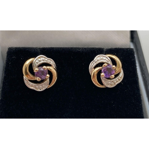 5 - A pair of 9ct gold swirl design stud earrings set with central amethyst stones. Complete with butter... 