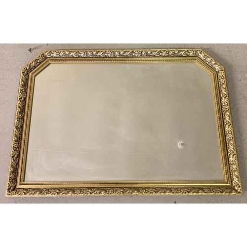 1377 - A large gilt framed over mantel mirror with shaped top. Approx. 73cm x 103cm.