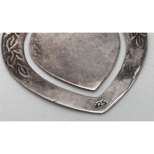 1062 - A silver heart shaped bookmark with floral and leaf decoration. Back marked 925. Approx. 4 x 4cm.