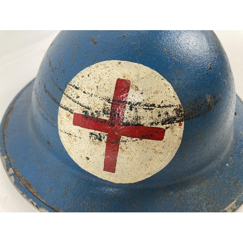 1120 - A WWII British Mk II steel helmet, painted blue. With red cross and rank marking for Corporal in RAF... 