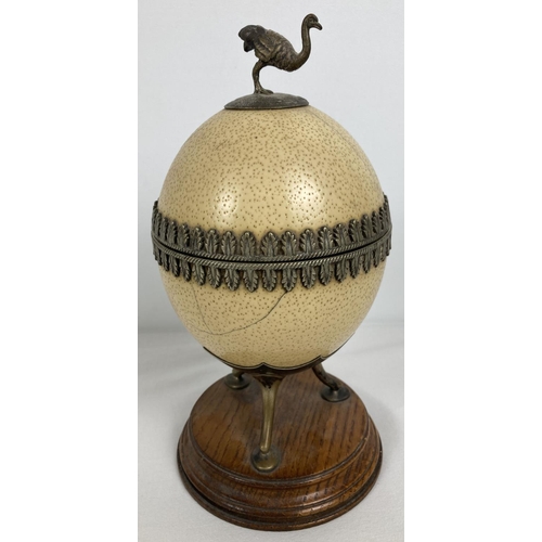 1296 - An antique lidded trinket pot made from an ostrich egg. With silver plated interior, decorative trim... 