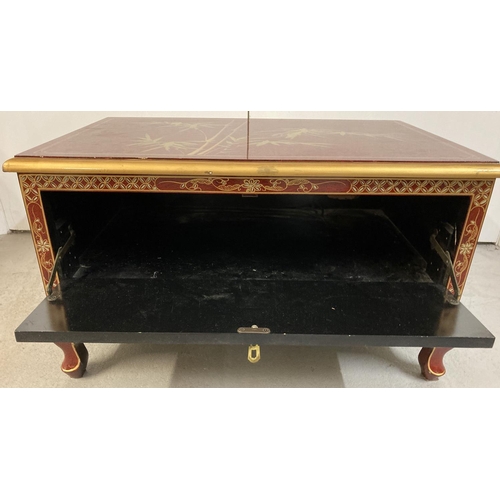 1382 - A oriental design red lacquer small coffee table/ unit with front pull down cupboard and small cabri... 