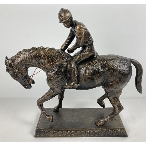 1099 - A large, heavy bronzed cast metal figurine of a horse and jockey. Approx. 39cm T x 42cm L.