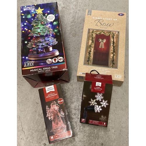 1312 - 4 boxed Christmas decorations. A large silver light up bow, a snowflake projector, an LED light up C... 