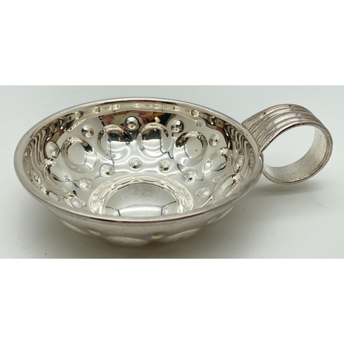 1078 - A French silver wine tasting cup with circular decoration to bowl and ridged detail to curled handle... 