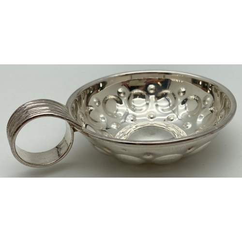 1078 - A French silver wine tasting cup with circular decoration to bowl and ridged detail to curled handle... 