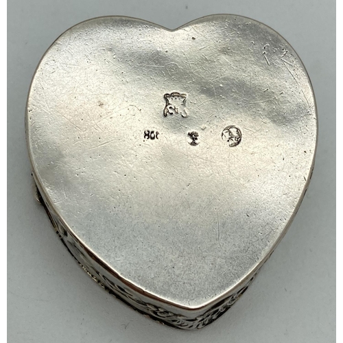 1080 - A continental 800 silver heart shaped pill/trinket box with classic figure and scroll decoration to ... 