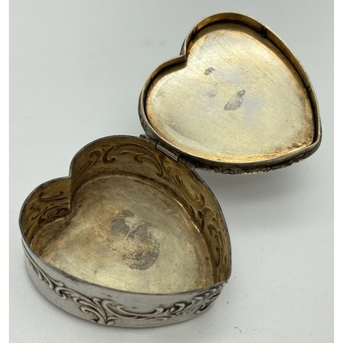 1080 - A continental 800 silver heart shaped pill/trinket box with classic figure and scroll decoration to ... 