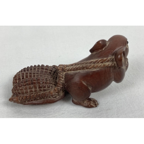 1194 - A carved wooden netsuke modelled as a mouse pulling a basket of ears of corn. Set with small mother ... 