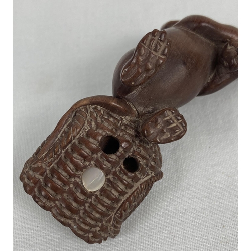 1194 - A carved wooden netsuke modelled as a mouse pulling a basket of ears of corn. Set with small mother ... 