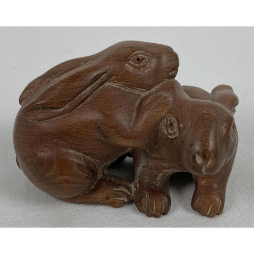 1198 - A small carved wooden figure modelled as 2 rabbits. Approx. 3.5cm tall x 5.5cm long.