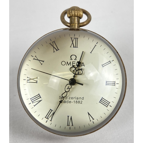 1128 - A brass bound, desk top glass ball watch with Roman Numeral markers and top winder. Approx. 6cm diam... 